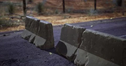 Concrete barriers block access on a remote desert road during dusk Stock Illustration