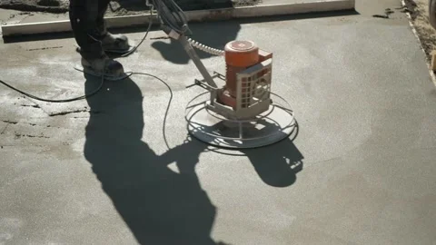 Concrete is bein smoothened by a construction worker on a construction site. Stock Footage
