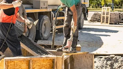 Concrete is being poured into forms to create a solid foundation at a constru 写真素材