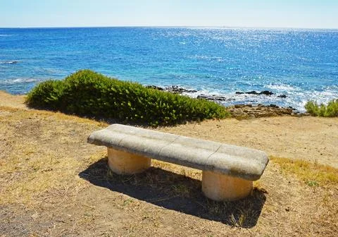 Concrete bench on the seashore Stock Photos