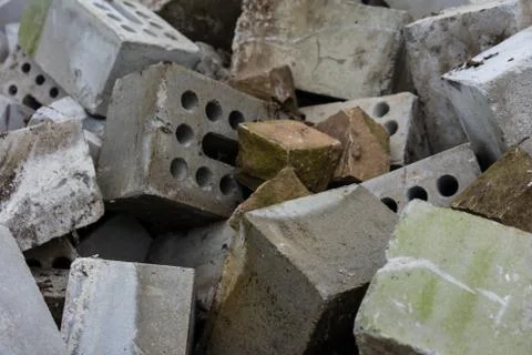 Concrete bricks construction material laying in skip on each other heap Stock Photos