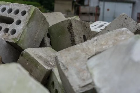 Concrete bricks construction material laying in skip on each other heap Stock Photos