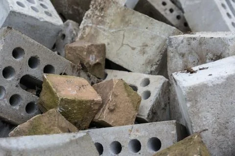 Concrete bricks construction material laying in skip on each other heap Stock Photos