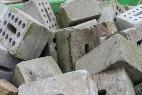 Concrete bricks construction material laying in skip on each other heap Stock Photos