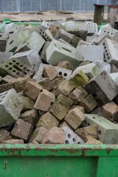 Concrete bricks construction material laying in skip on each other heap Stock Photos