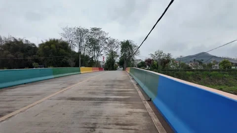 Concrete bridge with brightly colored painted railings crossing Stock Footage 332576774