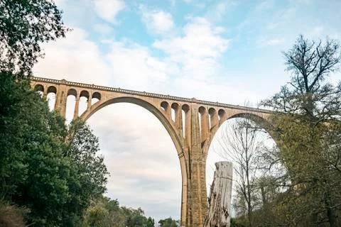 Concrete bridge over a cloudy background with several eyes in its structure t Stock Photos