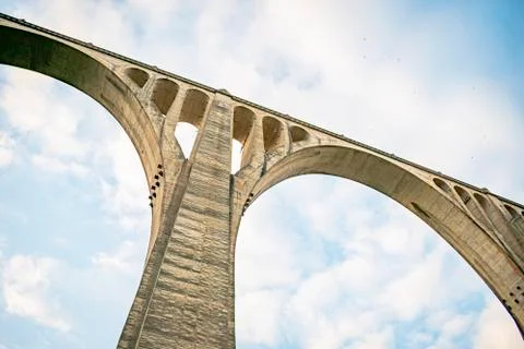 Concrete bridge over a cloudy background with several eyes in its structure t Stock Photos