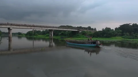 Concrete bridge over river with small wooden boats near bank at dusk Stock Footage 342158835