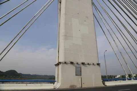 Concrete bridge pylon close-up with cable stays, streetlight, and clear sky.. Stock Photos