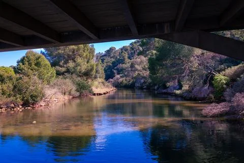 Concrete bridge structure spanning natural river landscape Stock Photos