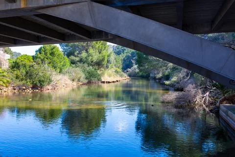 Concrete bridge structure spanning natural river landscape Stock Photos