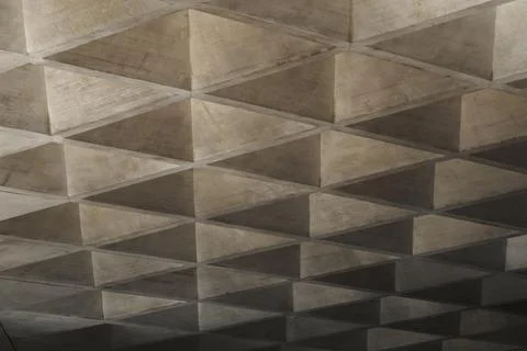 Concrete brutalist ceiling featuring geometric triangular waffle slab pattern 写真素材