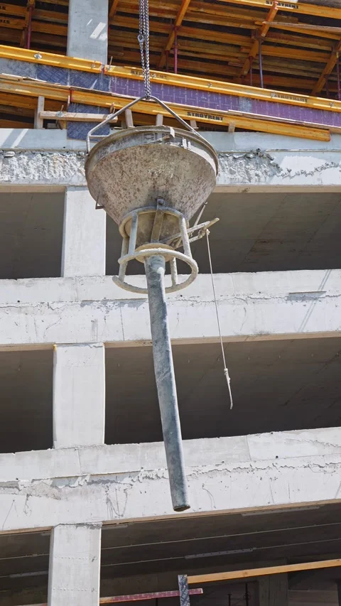 Concrete Bucket and Flexible Drop Chute Swinging From Tower Crane at Stock Footage 346569047