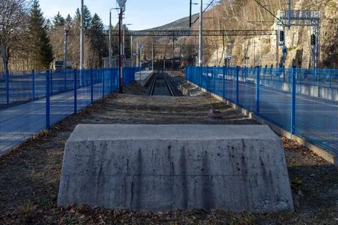 A concrete buffer stop stands at the end of a railway track at an empty train Stock Photos