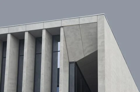 Concrete building facade with deep vertical columns and geometric shadows. Stock Photos