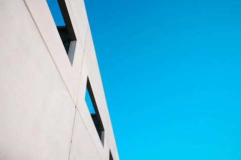 Concrete building with large windows open to the outside and a blue-green sky Stock Photos
