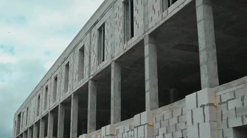 A concrete building structure is under construction in an urban area. Dark Stock Footage 339095763
