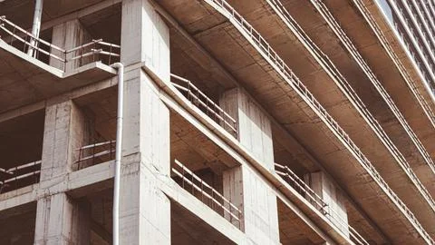 Concrete building under construction with exposed framework and scaffolding Fotos de archivo
