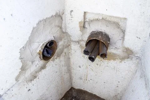 Concrete cable pit with embedded underground cable ducts for laying and Stock Photos