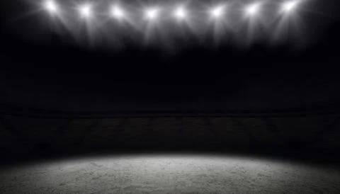 Concrete circle patch is glowing under overhead spotlights over dark seating in Stock Photos