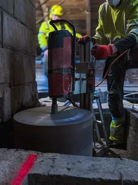 Concrete core drilling creating large circular slab opening. Stockfoto's