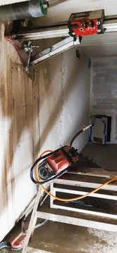 Concrete core drilling machine creating circular opening in structural wall Stock Photos