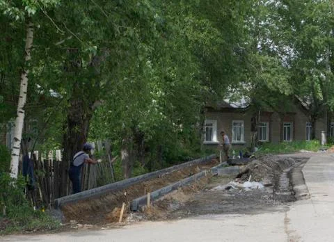 Concrete curb installation. String line level guide is stretched parallel to  Stock Photos