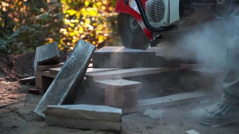 Concrete cutting machine. A worker in the park area cuts heavy slabs for a Video stock 120864212
