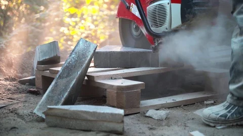 Concrete cutting machine. A worker in the park area cuts heavy slabs for a Video stock 120865051