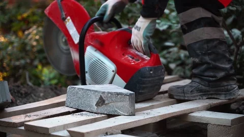 Concrete cutting machine. A worker in the park area cuts heavy slabs for a Video stock 120868065