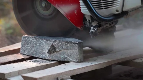 Concrete cutting machine. A worker in the park area cuts heavy slabs for a Video stock 120868804