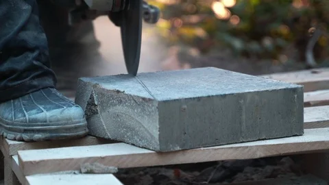 Concrete cutting machine. A worker in the park area cuts heavy slabs for a Video stock 120870109