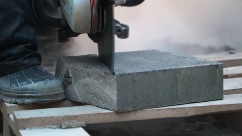 Concrete cutting machine. A worker in the park area cuts heavy slabs for a Video stock 120870812