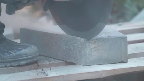 Concrete cutting machine. A worker in the park area cuts heavy slabs for a Video stock 120872442
