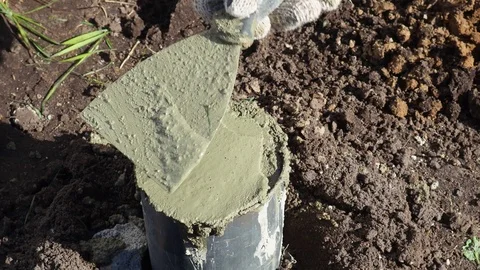Concrete cylinder Pipe cemente, worker with work gloves, holding a trowel putty  Stock Footage 117409349