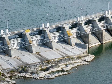 Concrete dam with multiple gates stands prominently Stock Photos