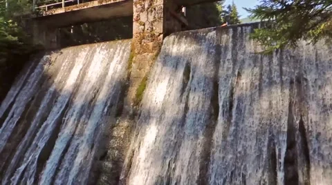 Concrete dam wall with falling waterfall stream in the forest Stock Footage 61376298