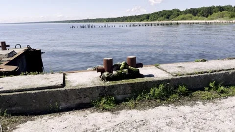 Concrete dock with mooring post facing calm waters Stock Footage 305655991