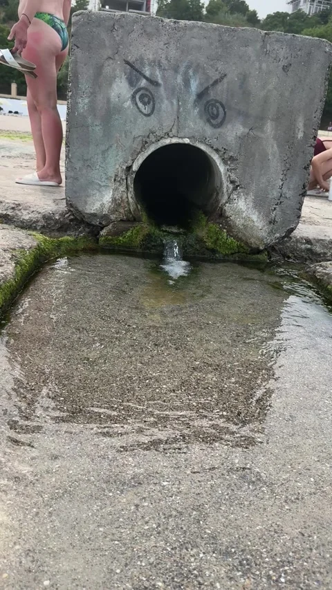 Concrete drain pipe with drawn face on beach Stock Footage 339730432
