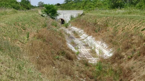 Concrete Drainage Culvert Pipe Under Road in Rural Landscape Stock Footage 337554866