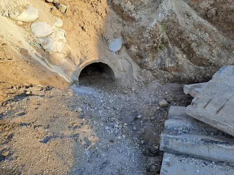 Concrete drainage pipe or culvert tunnel under a dirt hill Stock Photos