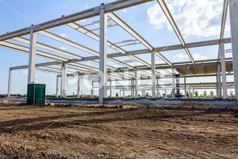 Concrete edifice under construction with mobile plastic toilet Stock Photos