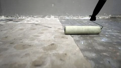 Concrete floor primer. The process of applying primer with a roller to a co.. Stock Photos
