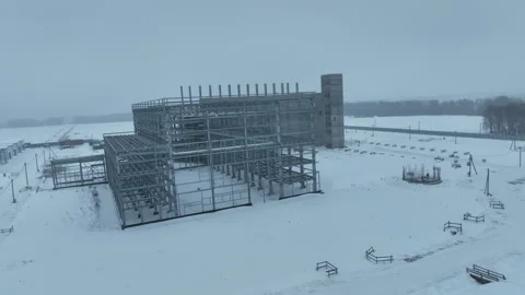 Concrete framework rises across snowy industrial territory Video stock 327807210