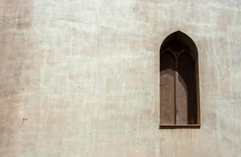 Concrete gray wall with arabic window covered with rusty fine mesh Foto stock