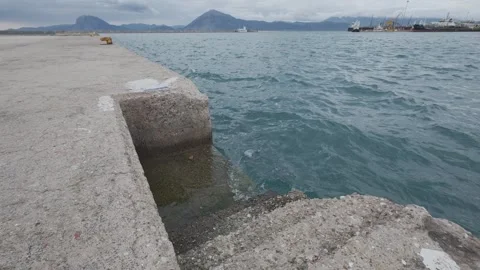 Concrete Harbor Steps Leading Into Rough Sea With Industrial Port Stock Footage 338105052