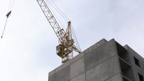 Concrete high-rise building under construction with yellow tower crane. Stock Footage 247274751