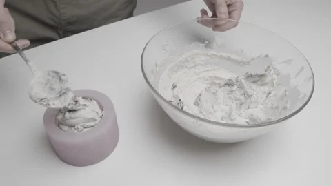 Concrete is inserted into a silicone mold to create a handmade candle Stock Footage 182474864