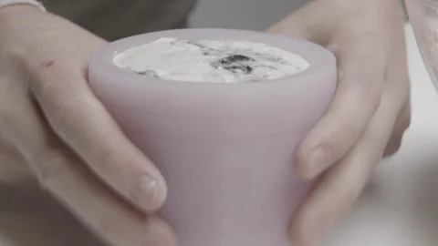 Concrete is inserted into a silicone mold to create a handmade candle Stock Footage 182846534